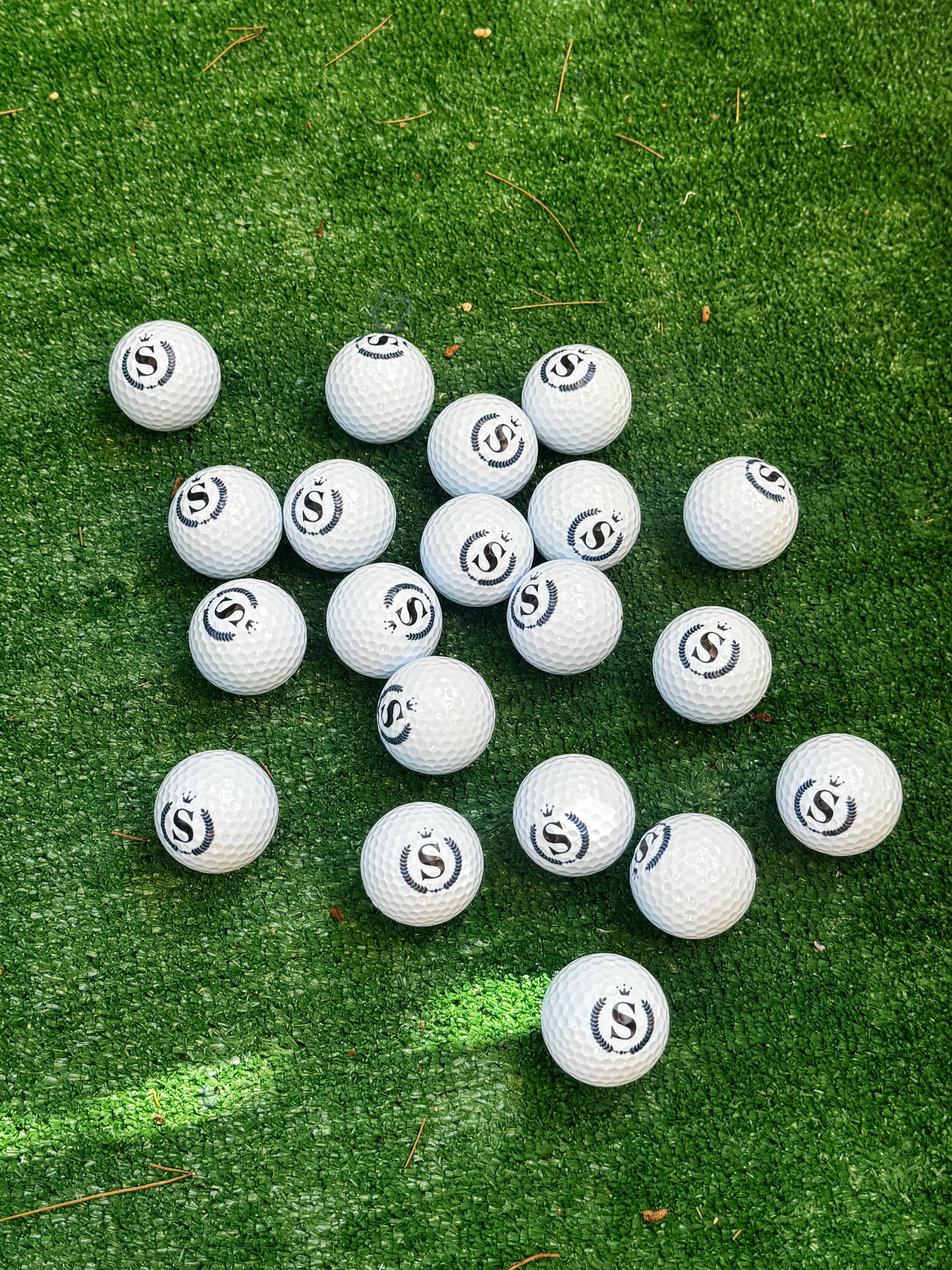 Custom logo engraved golf balls on green grass - bulk order
